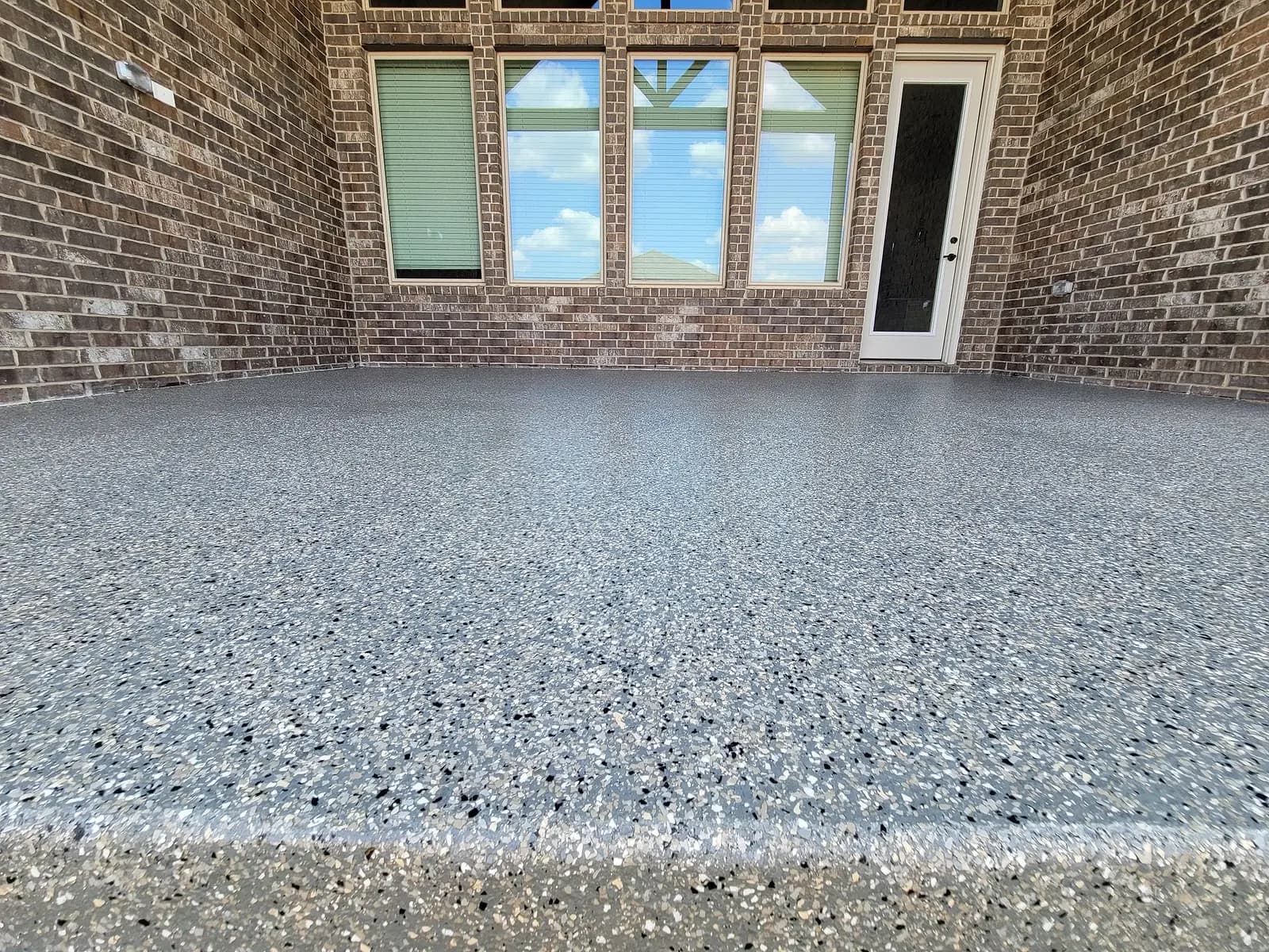 Covered patio with a wood ceiling and a coated concrete floor