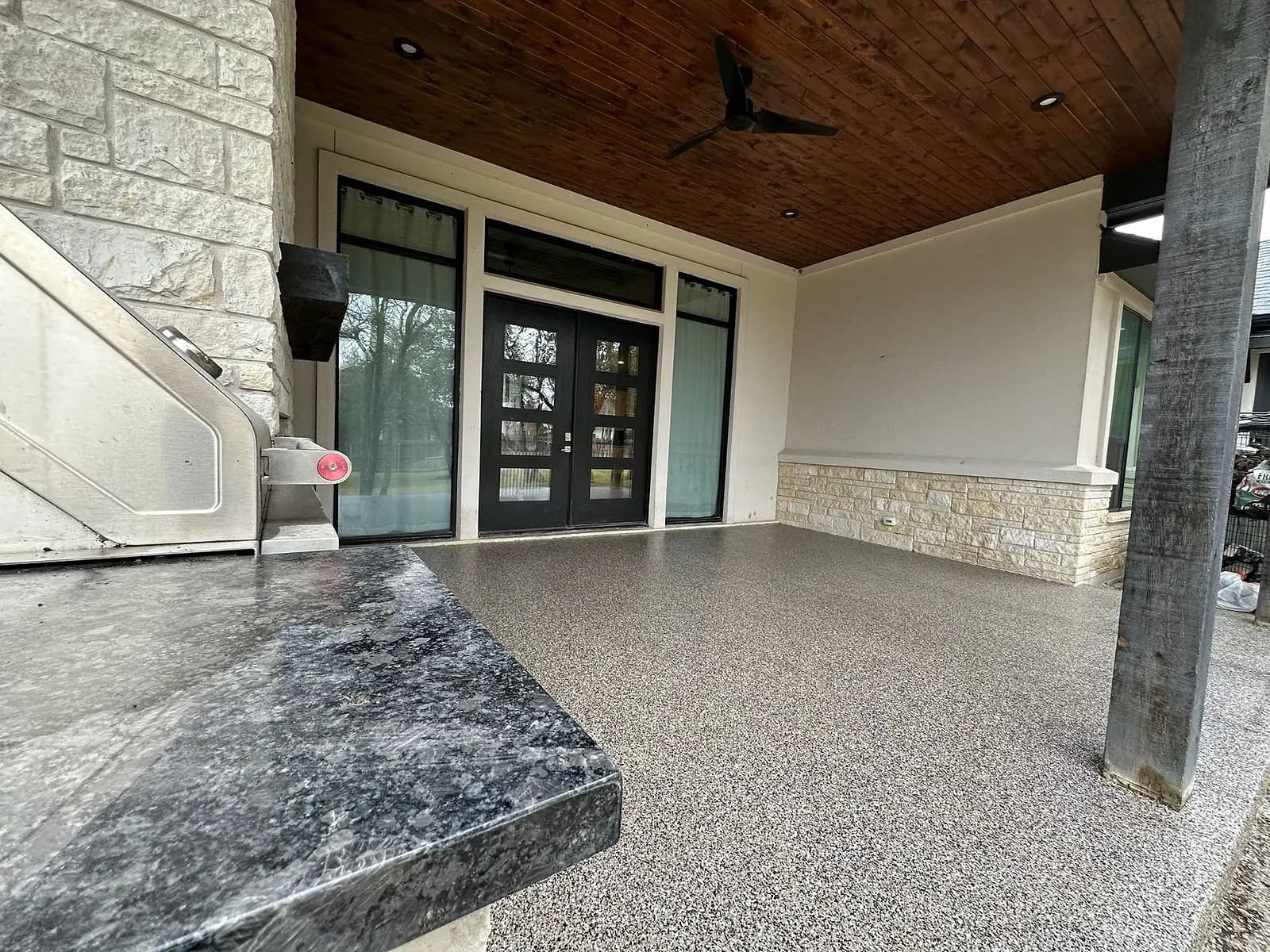 Covered patio with an outdoor kitchen and a flake floor coating