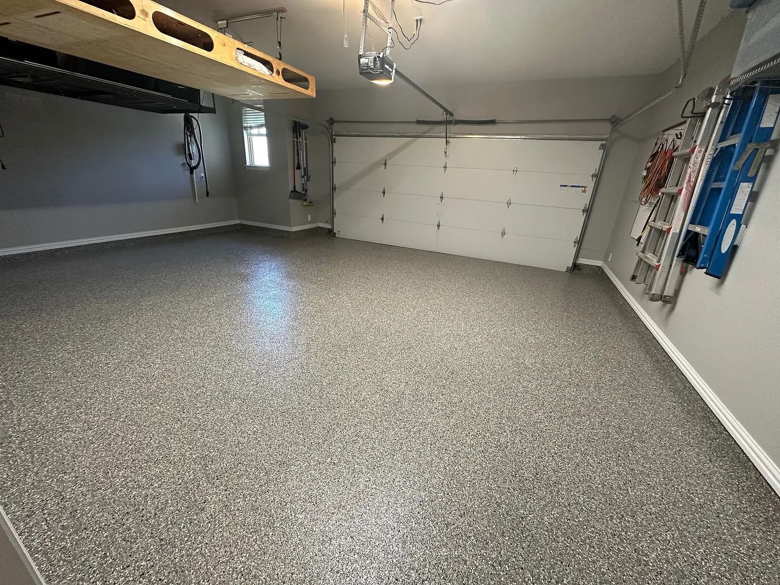 Flake-coated garage floor under overhead storage racks and wall hooks