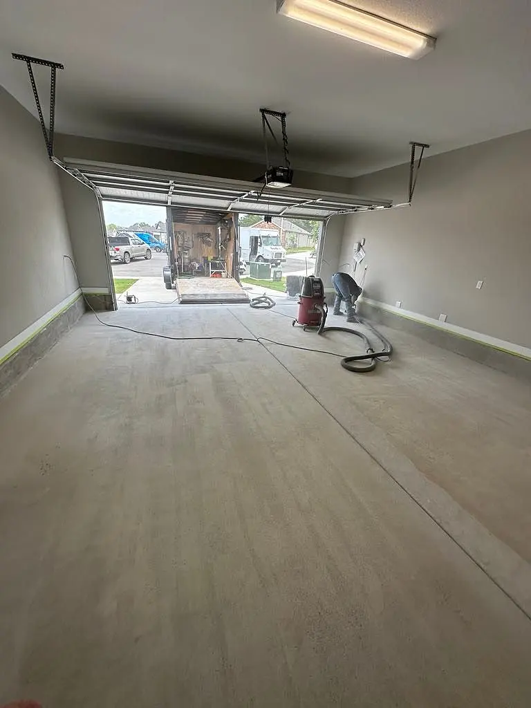 Empty two-car garage with a new light grey floor coating