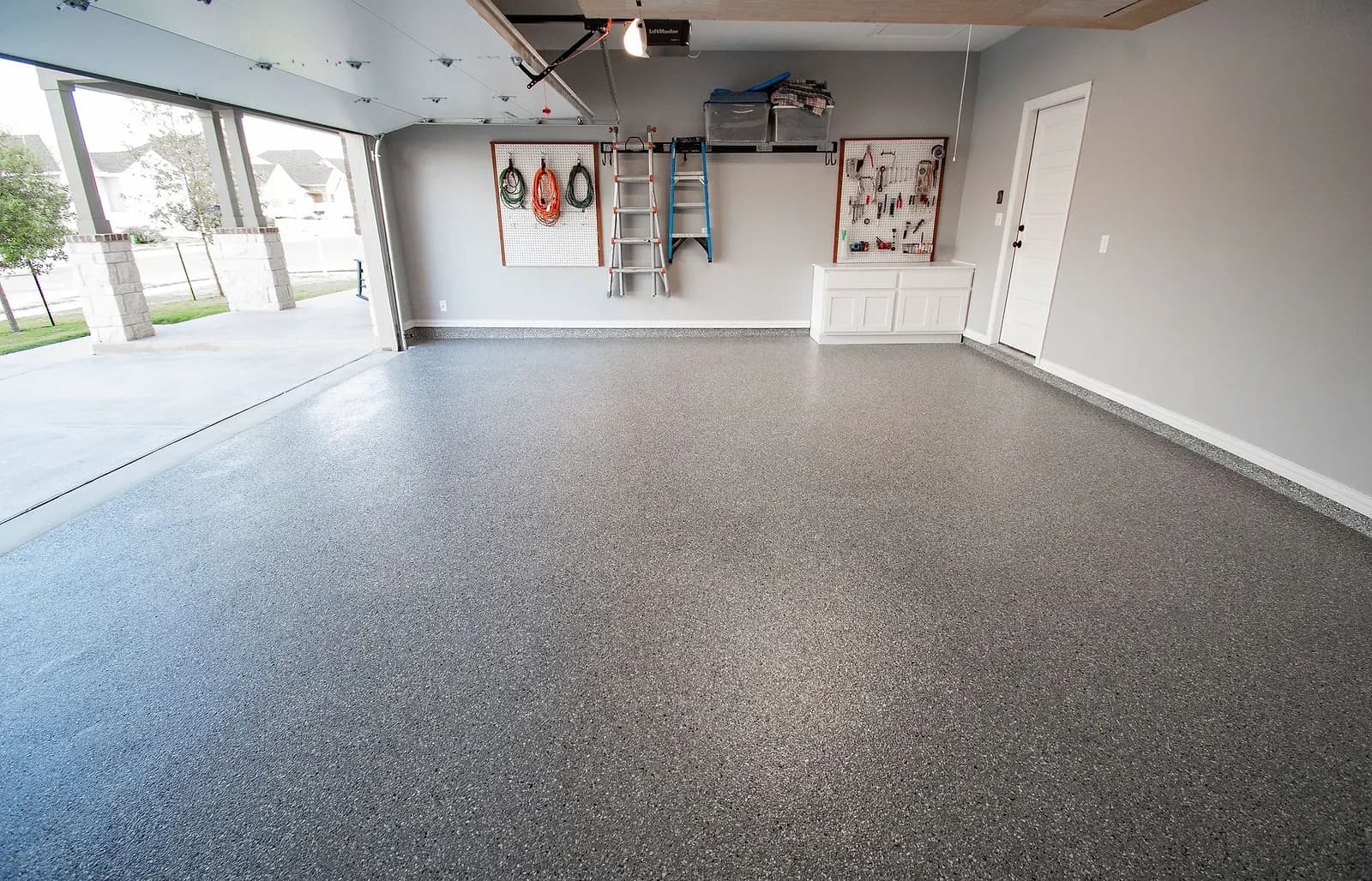 Finished flake garage floor with the garage door open to the driveway