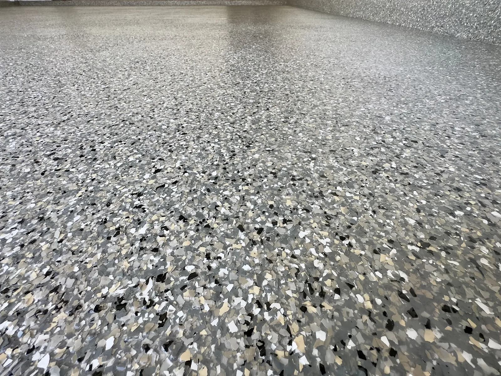 Close-up of grey, black and white flake in a polyaspartic topcoat