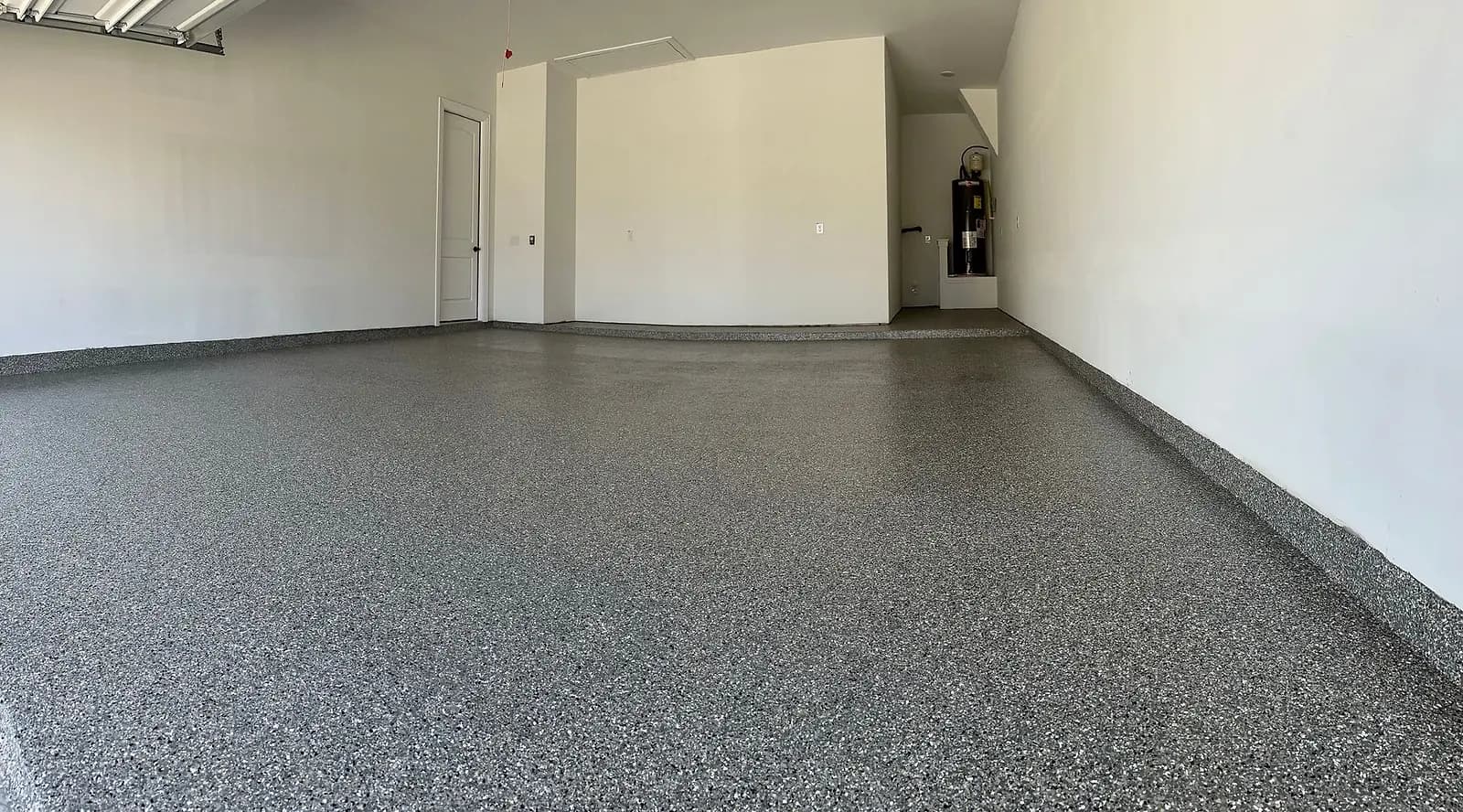 Empty garage with a new flake floor running to the back wall