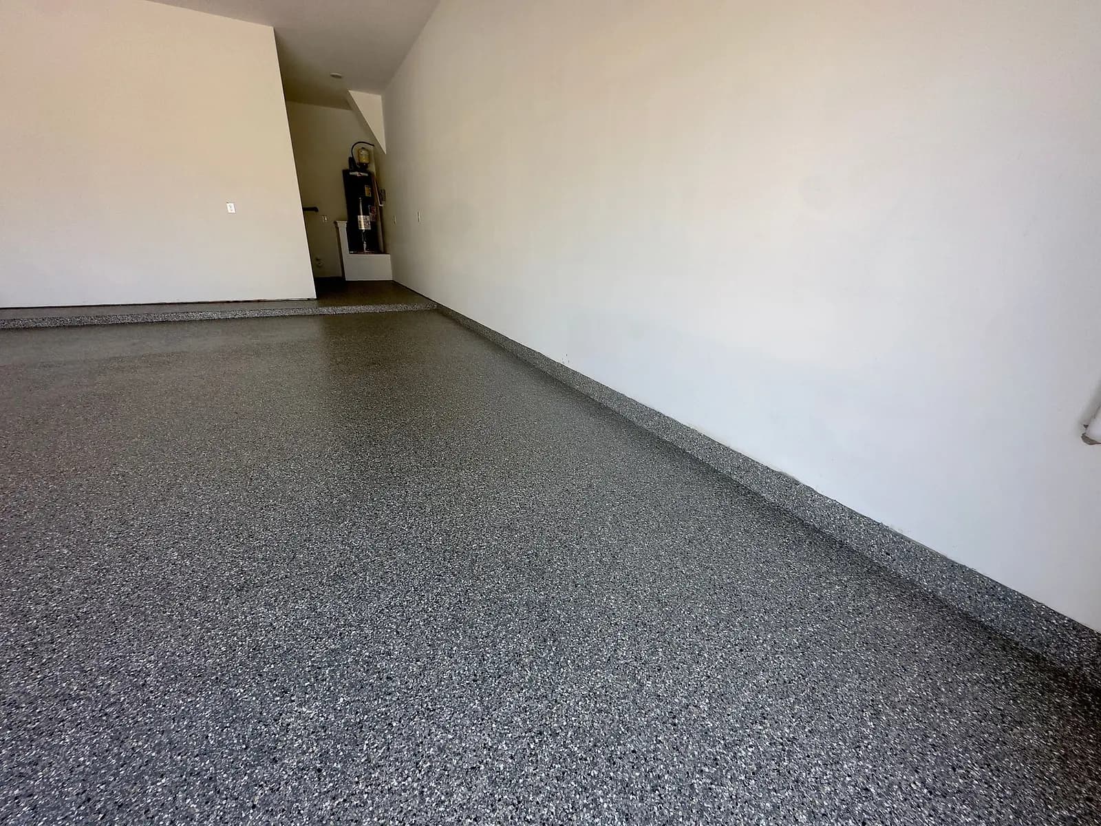 Flake floor coating meeting the garage wall, with a coved edge