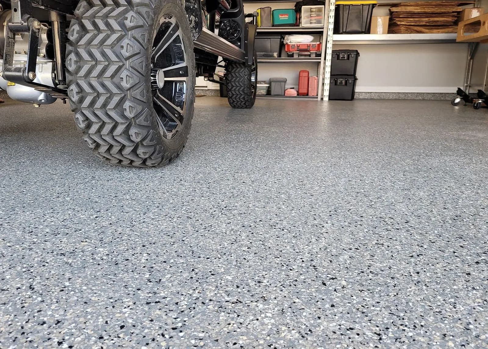 Golf cart parked on a freshly coated flake garage floor
