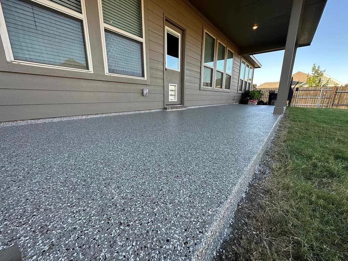 Coated patio running along the side of a home, lawn beside it