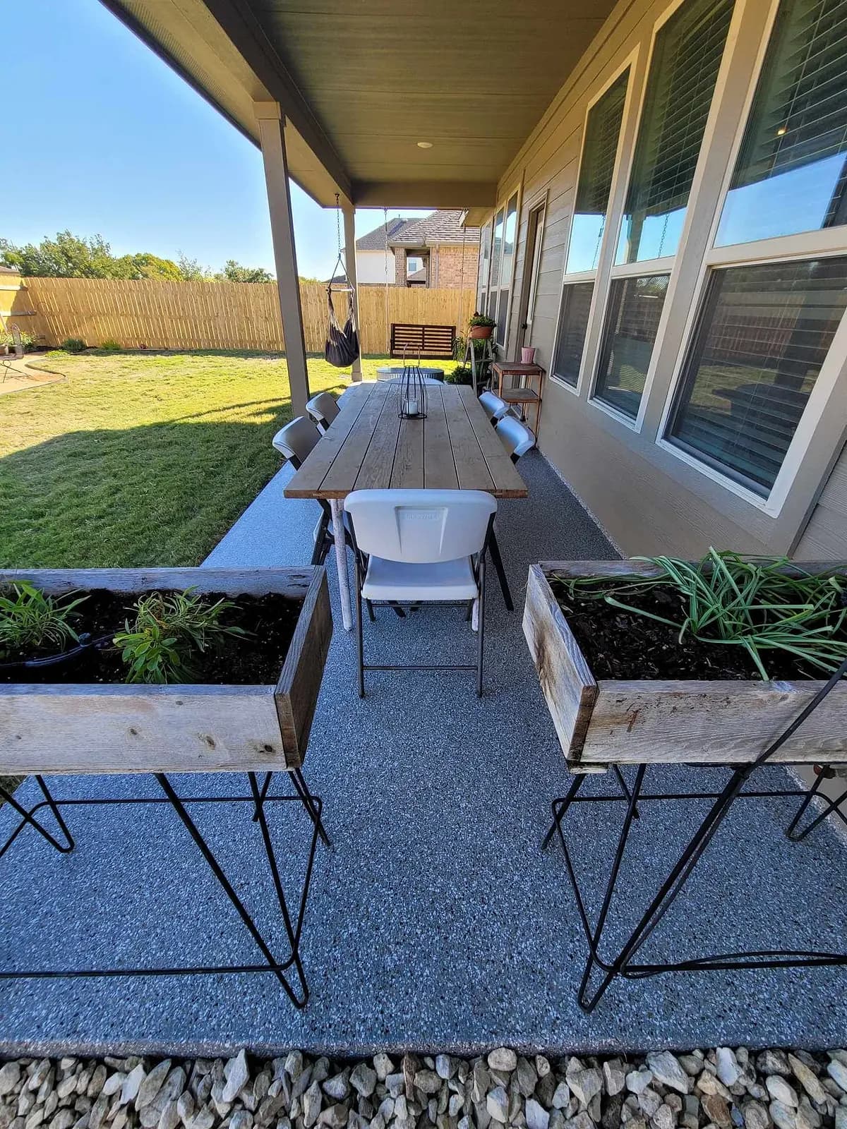 Long back porch with a table and planters on a coated floor